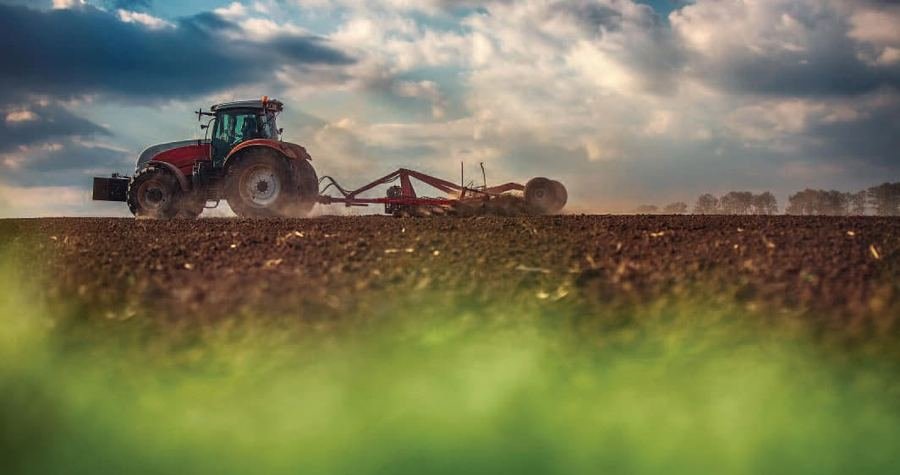 Tractor con sembradora trabajando el campo para siembra